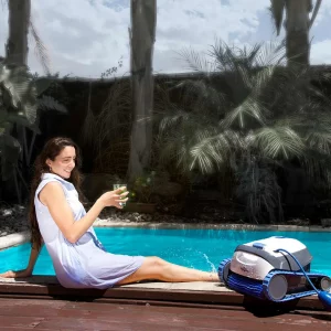 Mytronics Poolroboter DOLPHIN-S100 mit pool im hintergrund und einer frau die am poolrand sitzt