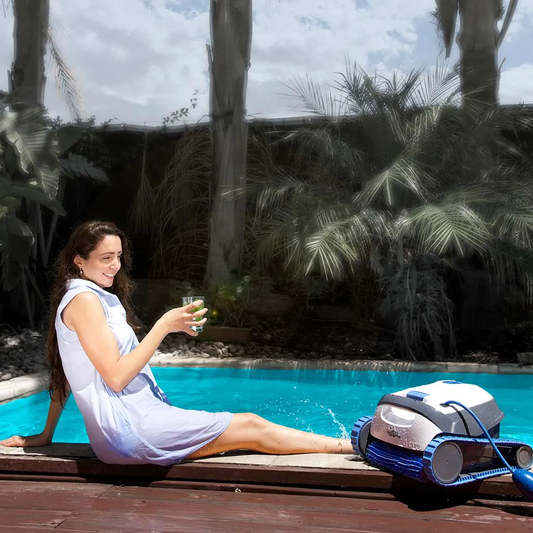 Mytronics Poolroboter DOLPHIN-S100 mit pool im hintergrund und einer frau die am poolrand sitzt